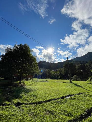 a field of grass with the sun in the sky at Aungha forest view บ้านชวนฝัน in Ban Sop Mae Klang