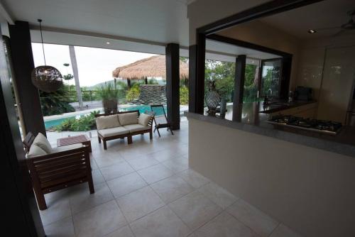 a kitchen and living room with a view of a pool at Luxury rainforest eyrie with panoramic views in Mossman