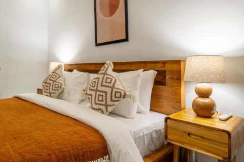 a bedroom with a bed with white pillows and a lamp at Stunning 2BDR Villa with Private Pool in CANGGU in Canggu