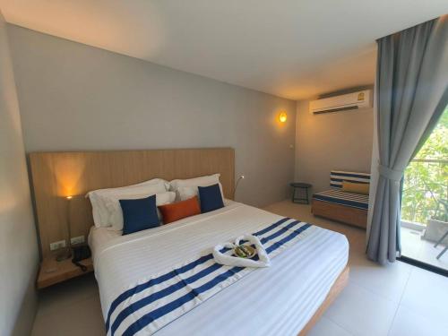 a bedroom with a large white bed with blue and orange pillows at Casa De Mar - Koh Samui in Chaweng