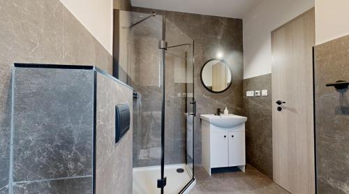 un baño con ducha y lavabo en SALAN Apartman Sereď, en Seredʼ