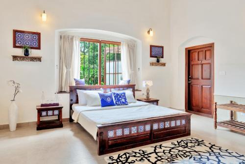 une chambre avec un lit et une grande fenêtre dans l'établissement SaffronStays Biccode Woodside Heritage, à Belūr
