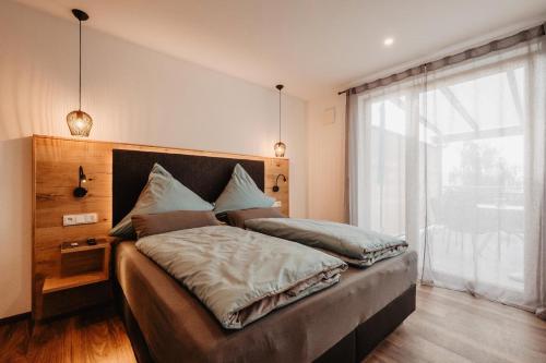 a bedroom with a bed with a large window at Rabenstein Suiten in Zwiesel