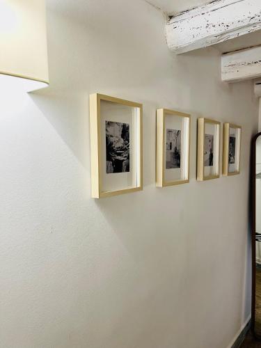 a row of framed photographs on a white wall at Butera Apartments Luxury in Palermo