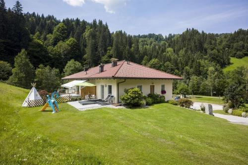 a small house on a grassy hill with a yard at Appartementhaus Glashütte in Kelchsau
