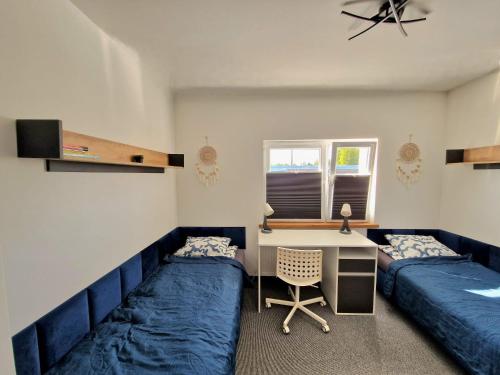 a bedroom with two beds and a desk and a desk at Apartamenty Promyk Wisełka in Wisełka