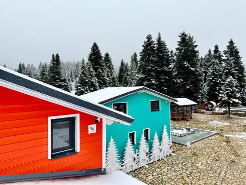 a house with a red white and blue at Casa de Madera in Pávliani