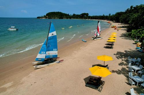a beach with umbrellas and chairs and boats on it at Sichon Cabana Beach Resort in Sichon