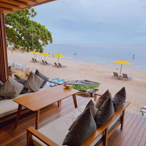 a living room with a couch and a table on the beach at Sichon Cabana Beach Resort in Sichon
