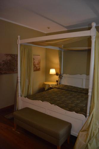 a bedroom with a canopy bed with a green comforter at Romantic Hotel Furno in San Francesco al Campo