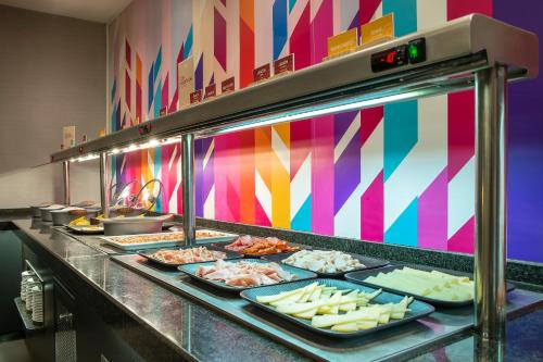 a buffet line with plates of food in a restaurant at Hotel Granada by Pierre & Vacances in Granada