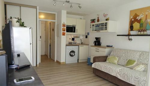 un salon avec un canapé et une cuisine dans l'établissement Studio proche port et plages, au calme (impasse), à Hyères