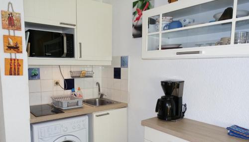 une cuisine avec un évier et une machine à laver dans l'établissement Studio proche port et plages, au calme (impasse), à Hyères