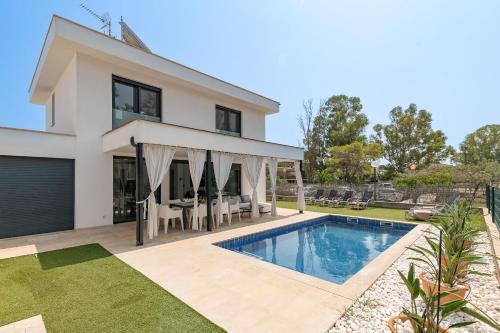 a villa with a swimming pool in front of a house at Beach Villa Cosins 1 Mel by Sealand Villas in Alcudia