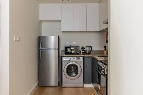 a kitchen with a refrigerator and a washing machine at Sahab - Rustic One BR Apt in Ḩiz̧āyib az Zānah