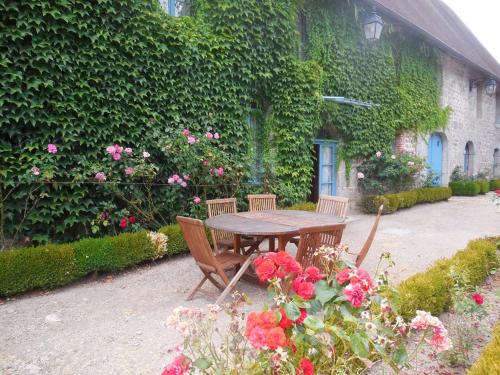 a table and chairs in front of a building with flowers at Homestay Château De Saint-Maixant in Saint-Maixant