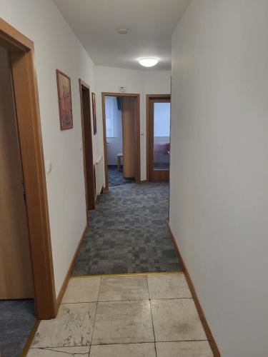 an empty hallway with doors and a tile floor at Komárov Apartment 2 in Komárov