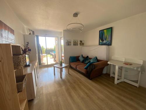 un salon avec un canapé et une table dans l'établissement Les pieds dans l'eau, à Canet