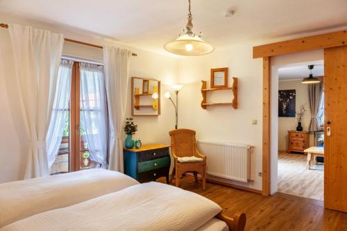 ein Schlafzimmer mit einem Bett, einem Schreibtisch und einem Stuhl in der Unterkunft Ferienwohnungen St Christoph in Mittenwald