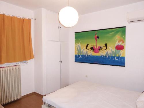 a bedroom with a painting on the wall at Cosy and quiet in Áyios Andréas Arkadias