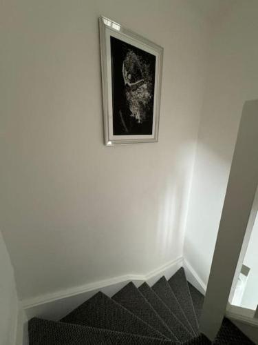 a picture of a cat on a wall next to a staircase at Work & Relax- Convenient 2-Bed House in Grimsby
