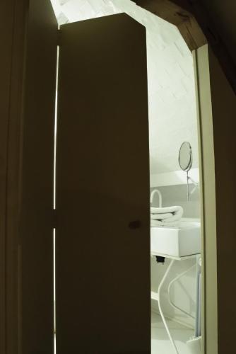 a door to a bathroom with a sink and a mirror at Cottage Montreuil-sur-mer Petit déjeuner inclus in Écuires