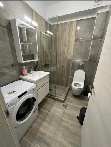 a bathroom with a washing machine and a toilet at Palm Residential in Orfánion