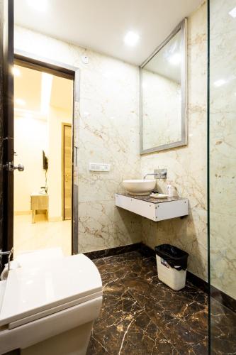 a bathroom with a toilet and a sink and a mirror at Hotel Red Castle - Karol Bagh - Where luxury meets comfort in New Delhi