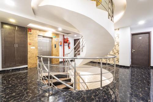 a spiral staircase in a lobby with black flooring at Hotel Red Castle - Karol Bagh - Where luxury meets comfort in New Delhi