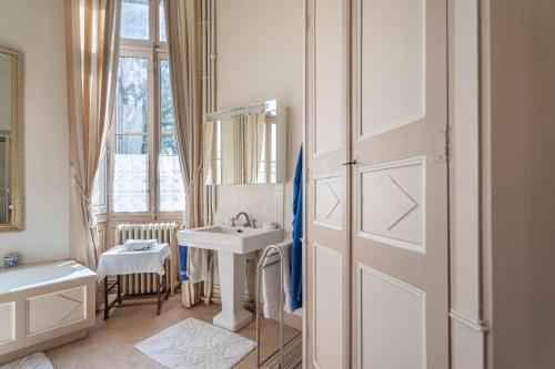 a bathroom with a sink and a mirror next to a door at Château de famille - Dangeul - 15 personnes in Dangeul