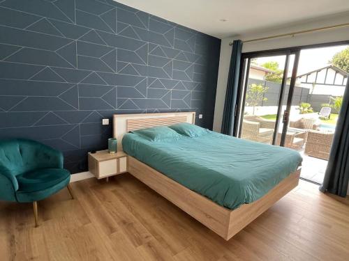 a bedroom with a bed and a blue wall at Magnifique villa SEREN avec piscine in Arcangues