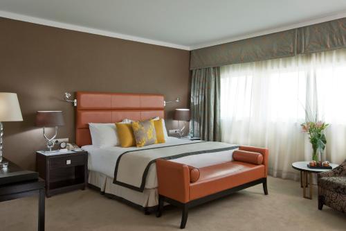 a bedroom with a bed and a chair at Hilton Cairo Heliopolis Hotel in Cairo