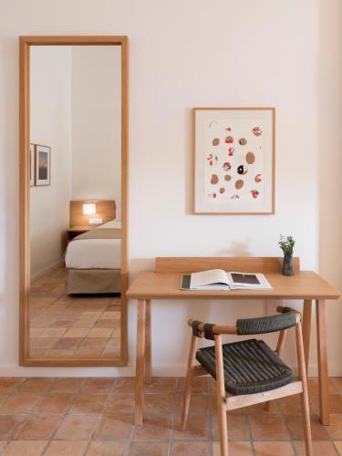 a mirror in a room with a desk and a bed at Es Figueral Nou Hotel Rural & Spa - Adults Only - Over 12 in Montuiri