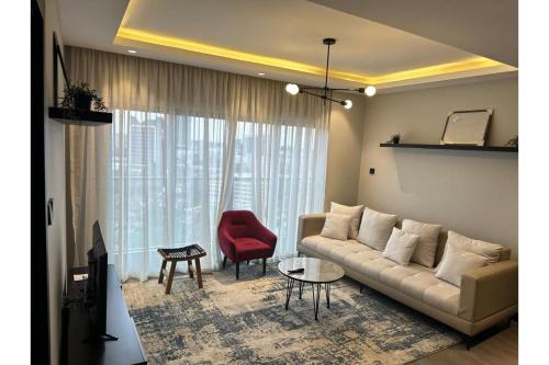 a living room with a couch and a red chair at Escada Serviced Apartments in Nairobi