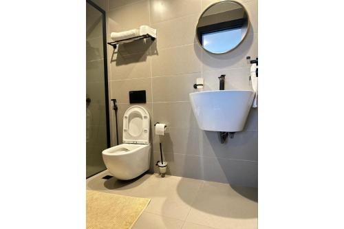 a bathroom with a toilet and a sink and a mirror at Escada Serviced Apartments in Nairobi