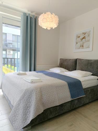 a bedroom with a large bed and a chandelier at Baltic Line - Nadwiślański Świt in Gdańsk