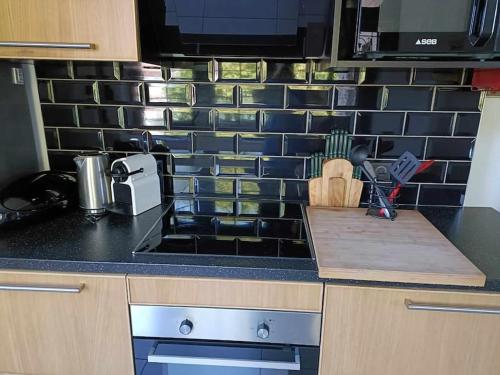 a kitchen counter with a black tile back splash at Le numéro 5 in Bar-le-Duc