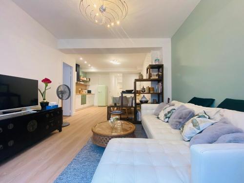 un salon avec un canapé blanc et une télévision dans l'établissement Casa Coeur Doutre, à Angers