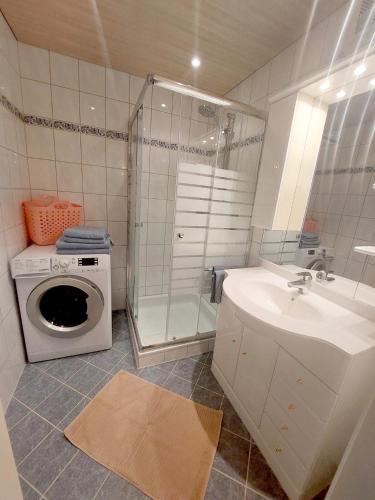 a bathroom with a washing machine and a sink at Landhaus Nageler in Westendorf