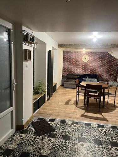 - un salon avec une table et un mur en briques dans l'établissement Maison 2 chambres, à Saint-Jean-sur-Mayenne