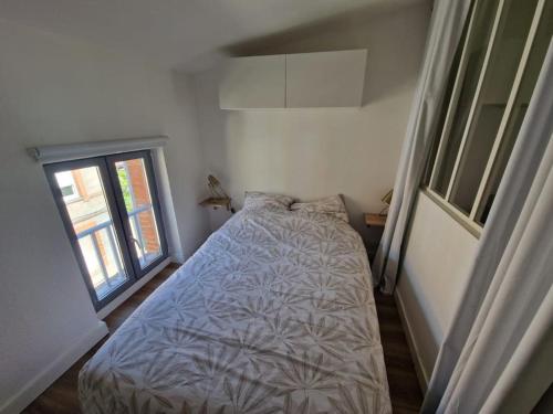 une petite chambre avec un lit et une fenêtre dans l'établissement Charmant T2 proche de la Gare Matabiau, à Toulouse