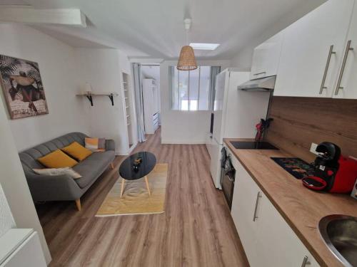 une cuisine et un salon avec un canapé et une table dans l'établissement Charmant T2 proche de la Gare Matabiau, à Toulouse