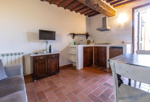 a room with a kitchen with a counter and a table at Agriturismo Palazzo Val Del Sasso in Villastrada