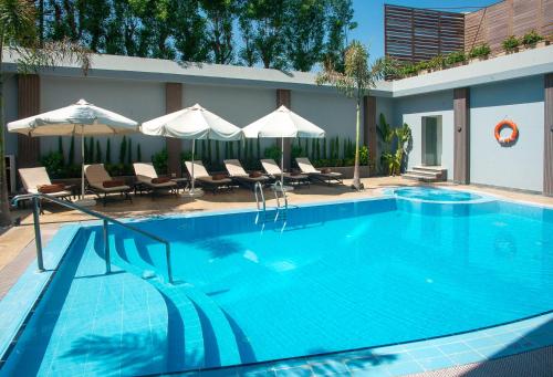 a large blue swimming pool with chairs and umbrellas at Novotel Cairo El Borg in Cairo