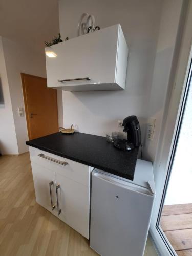 a small white kitchen with a black counter top at Innenstadt Perle Euskirchen in Euskirchen
