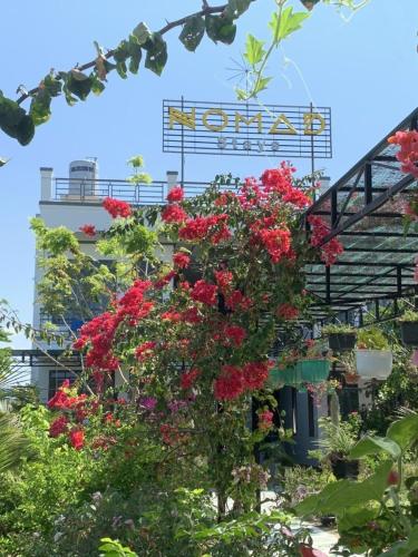 a building with red flowers in front of it at Nomad Stay in Phan Rang