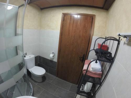 une salle de bain avec toilettes et porte en bois dans l'établissement Le refuge de la Panxa ¡Una experiencia mágica!, à Ur
