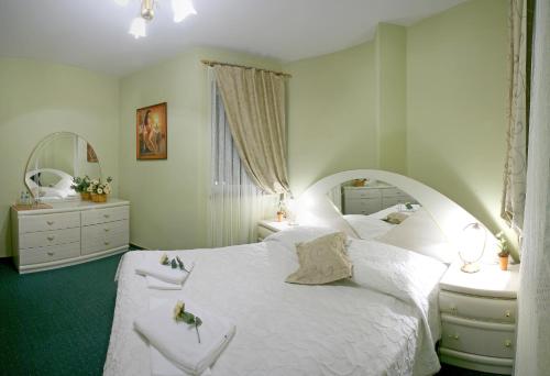 a bedroom with a large white bed and a mirror at Titanic in Białystok