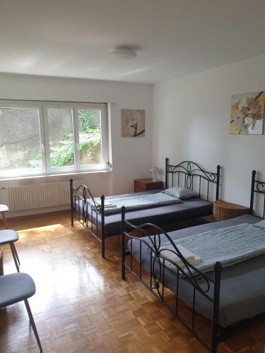 una habitación con tres camas y una ventana en Camera Massagno, en Lugano