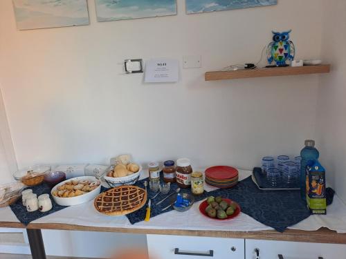 una tavola con prodotti alimentari e altri alimenti di I Sette Ulivi Bed and Breakfast a Tergu
